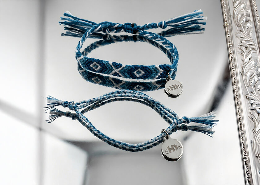 Hellblaues geflochtenes Freundschaftsarmband mit Logo-Charm und Schiebeknoten als individuelles Werbegeschenk